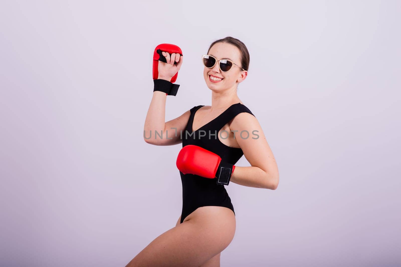 Studio portrait of a boxer female in bodysuit with gloves red