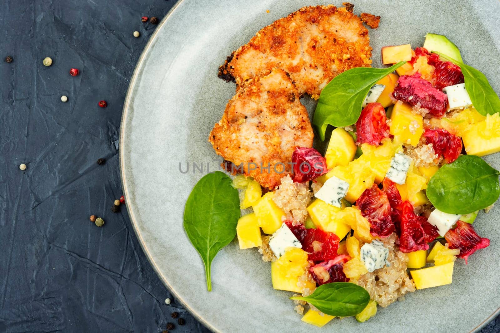Salad with fruit, chicken breast and quinoa. Fruits salad with meat. Close up