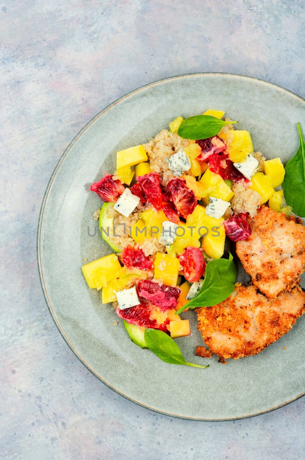 Salad with fruit, chicken breast and quinoa. Fruits salad with meat. Close up