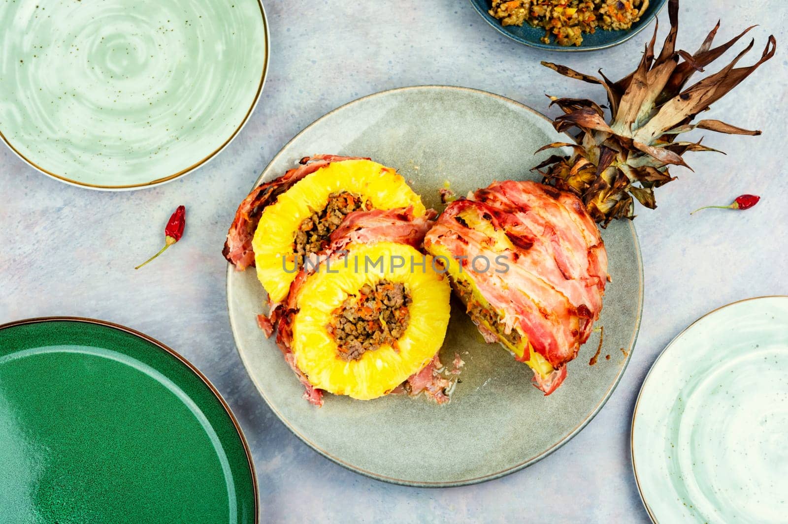 Baked pineapple stuffed with ground beef in bacon wrapped Chinese style