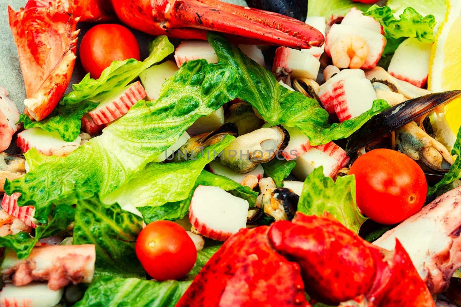 Tasty salad of oysters, mussels, lobster, lettuce and vegetables. Food background