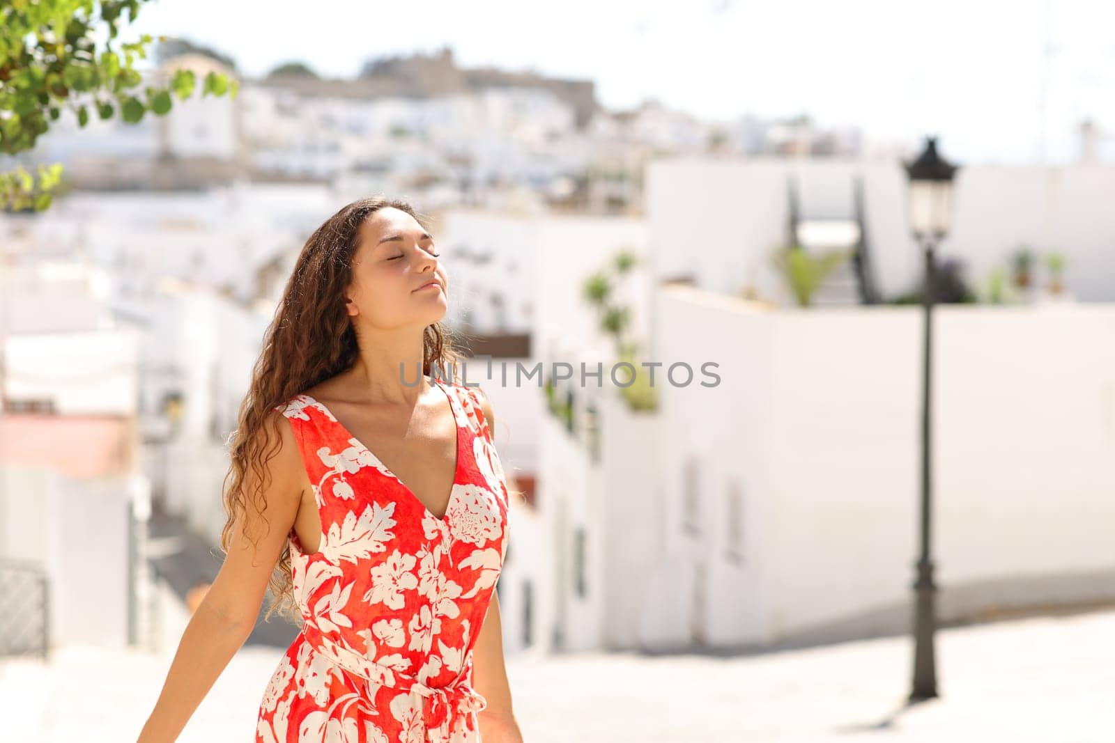 Tourist in red breathing fresh air in a white town street on summer vacation