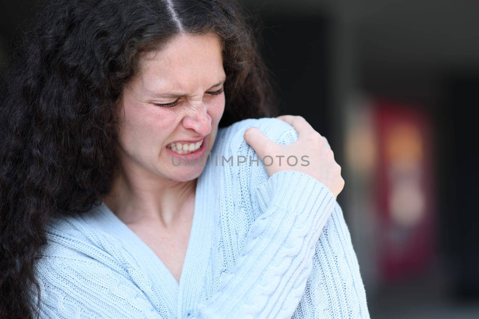 Woman suffering shoulder ache complaining in the street