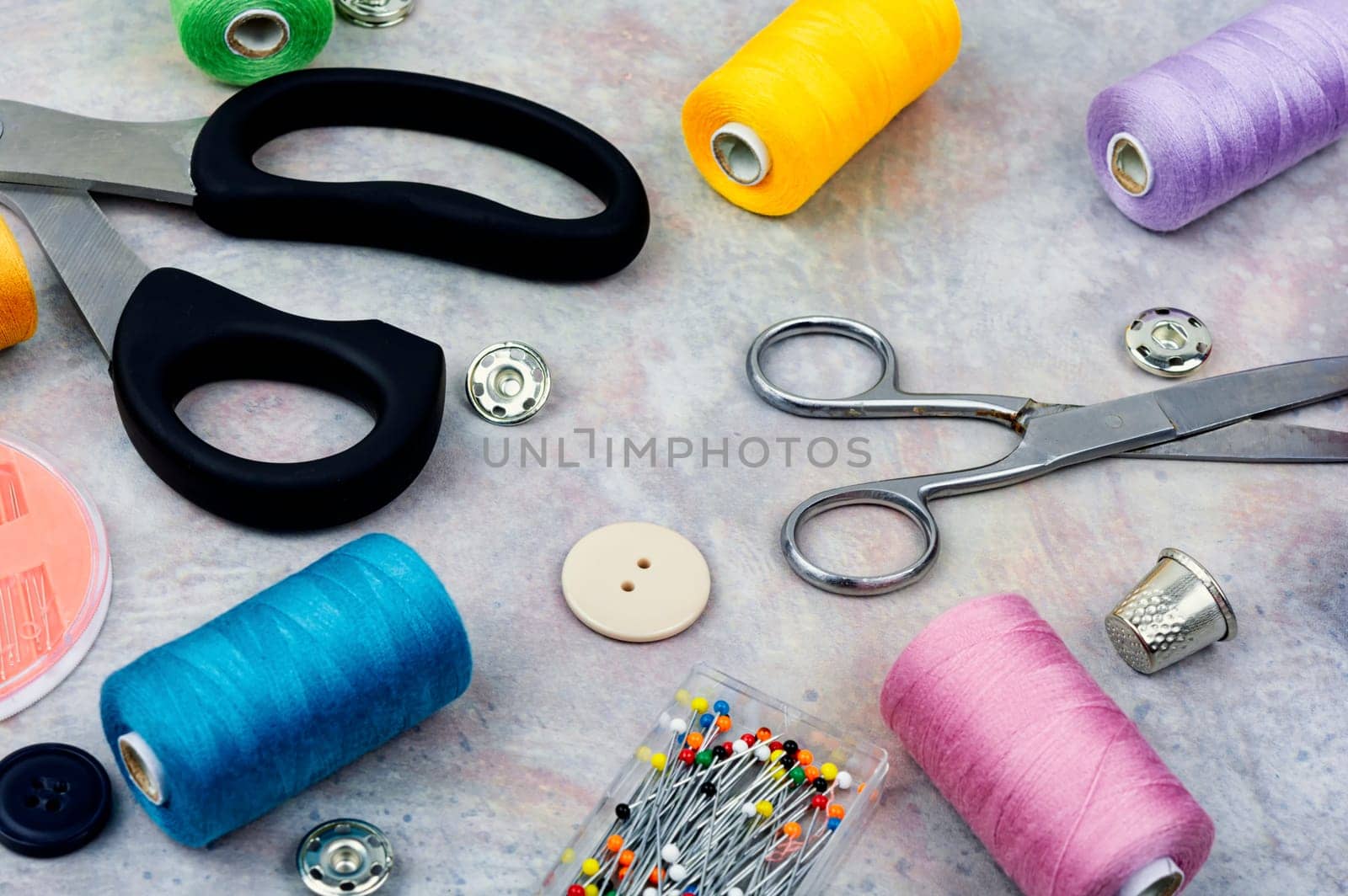 Home sewing kit, scissors, color threads, needles and buttons. Needlework concept