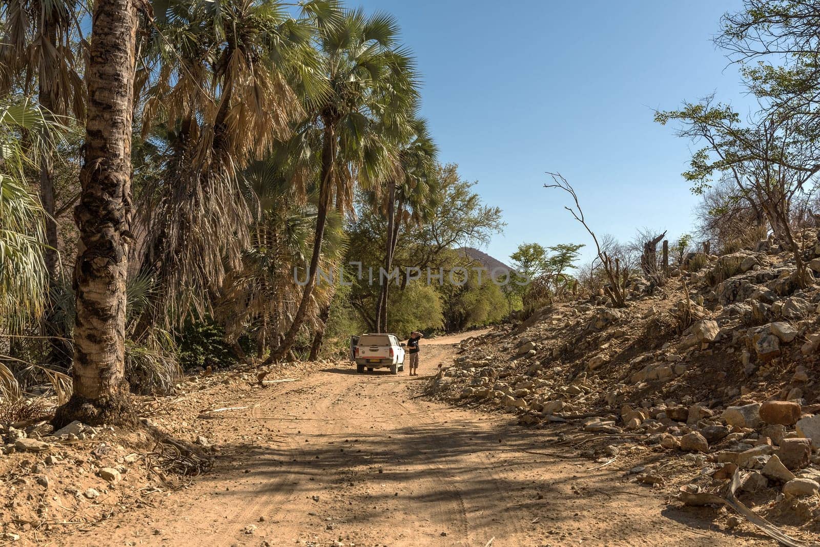 Car on a dusty gravel road along the Kunene River in northern Namibia
