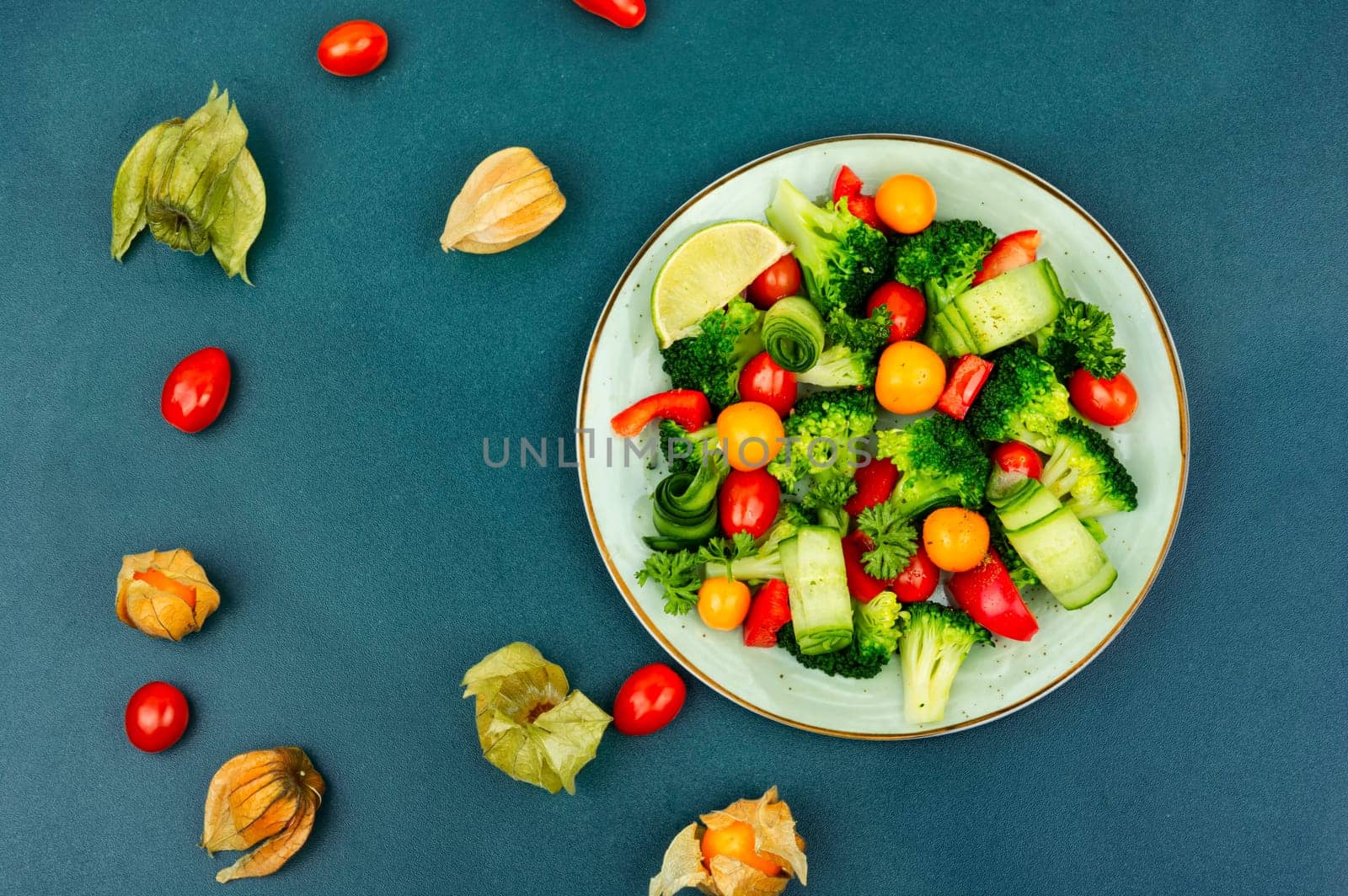 Vitamin salad with broccoli, tomato, cucumber and physalis. Healthy food concept, space for text