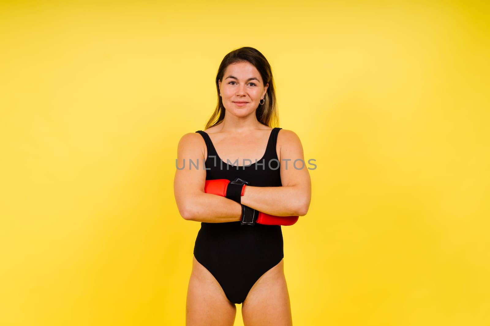 Cool female fighter in boxing bandages trains in a studio. Mixed martial arts.