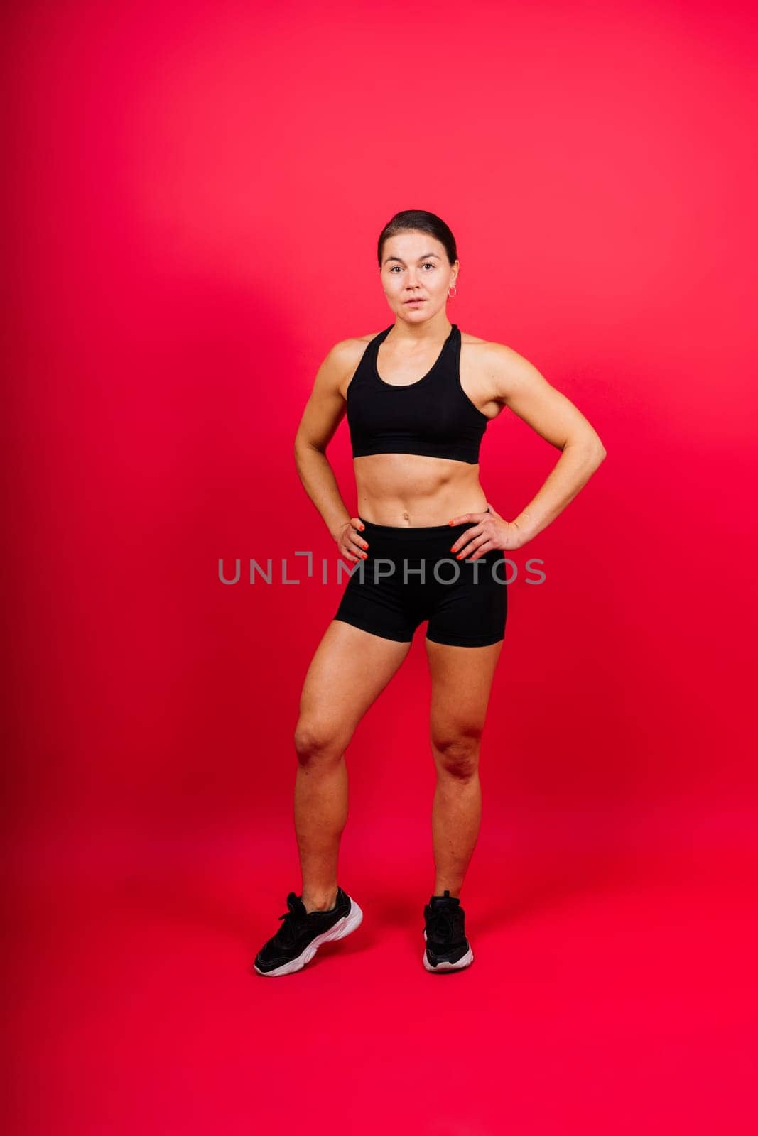 Cool female fighter in boxing bandages trains in a studio. Mixed martial arts.
