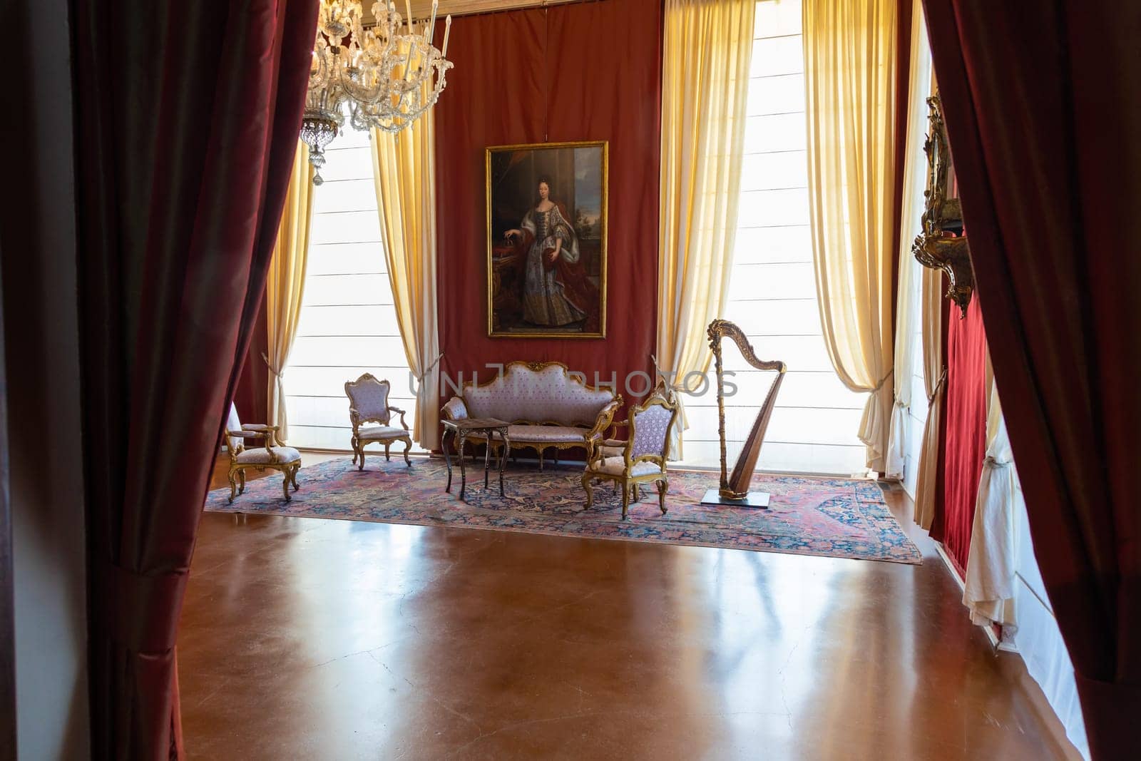 Venaria Reale, Italy - February 2023: luxury interior, old Royal Palace. Perspective with harp, window and baroque decoration.