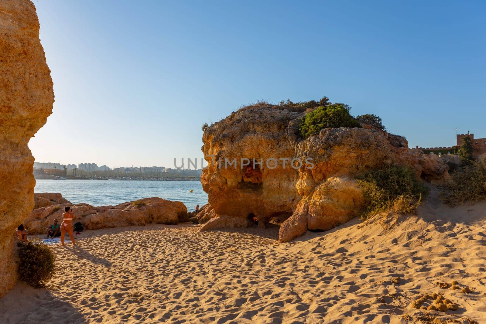 Ferragudo, Portugal - 25 August 2025: Beautiful seascape with beach, cave and ocean. Praia Grande beach. Ferragudo, Lagoa, Algarve, Portugal