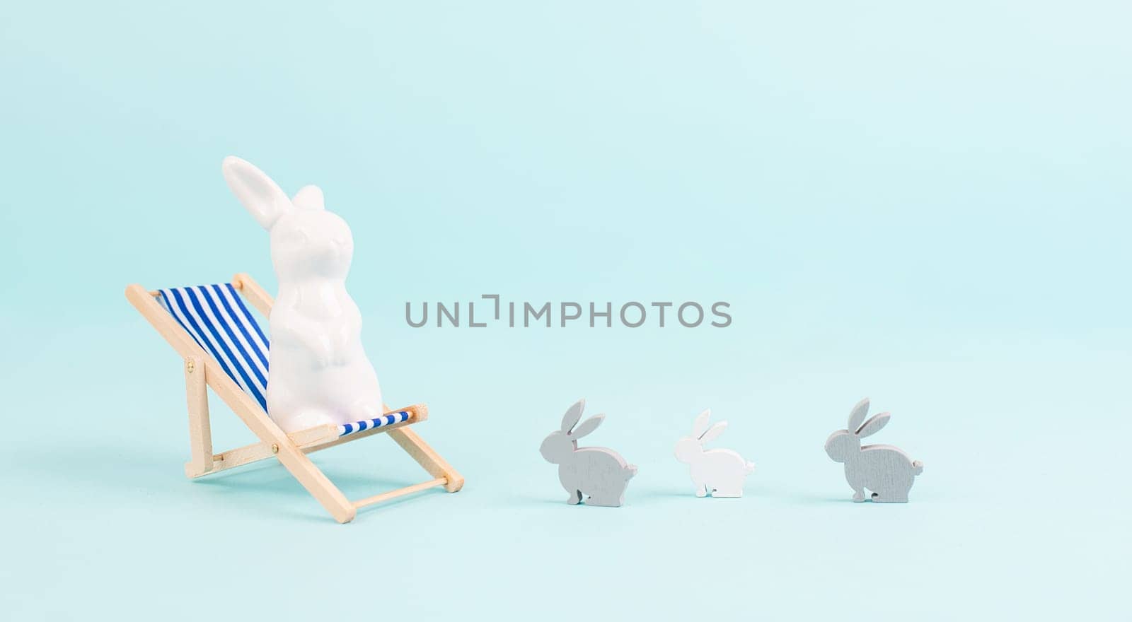 Bunny or rabbit sitting on lounge chair, kids next to mother, easter holiday, vacation by the sea