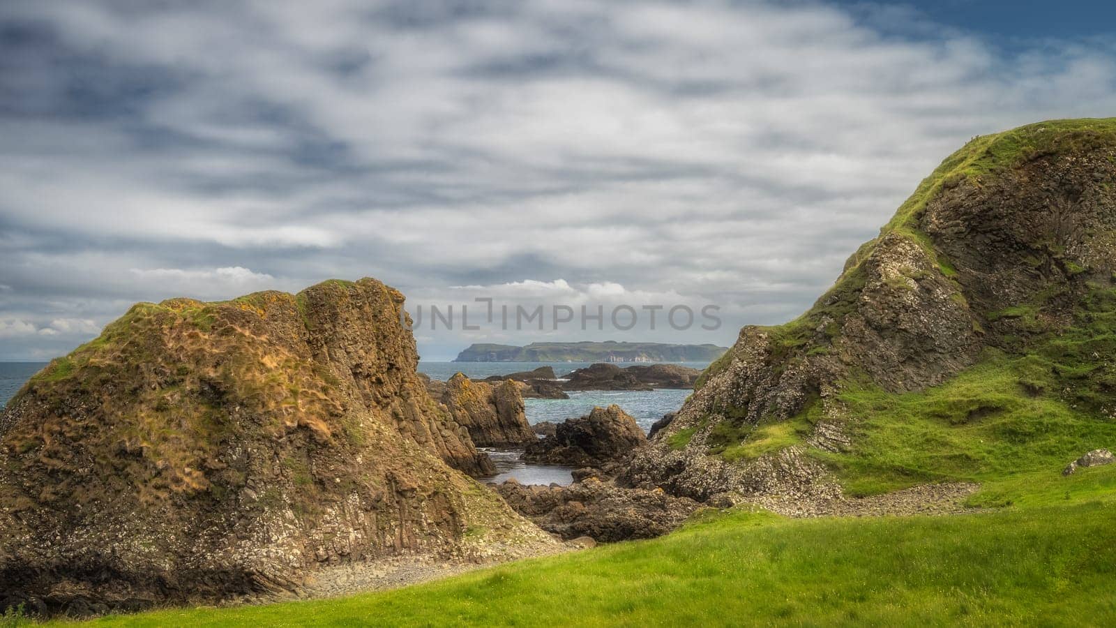 Beautiful coastline with hills, cliffs and small rocky islands on Causeway Coast at Ballintoy Harbour, County Antrim, Northern Ireland