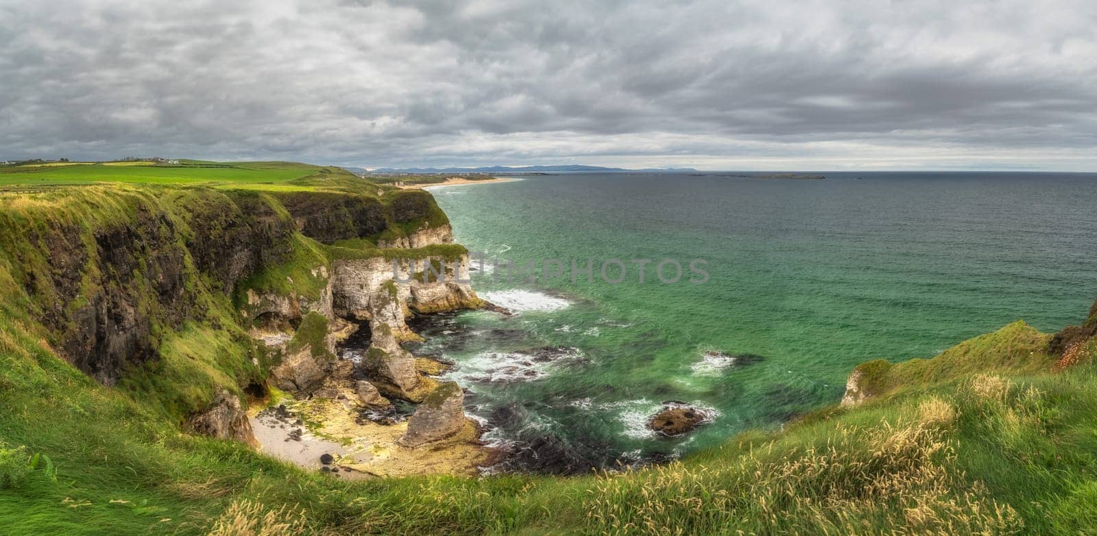 Panorama with white limestone rock formations and emerald water on beautiful Causeway Coast and Wild Atlantic Way, County Antrim, Northern Ireland