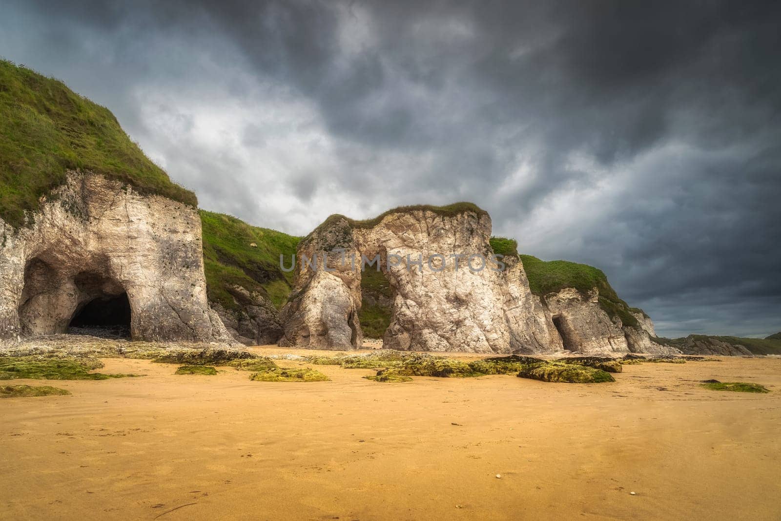 Panorama with white limestone rock formations and sandy beach on beautiful Causeway Coast and Wild Atlantic Way, County Antrim, Northern Ireland