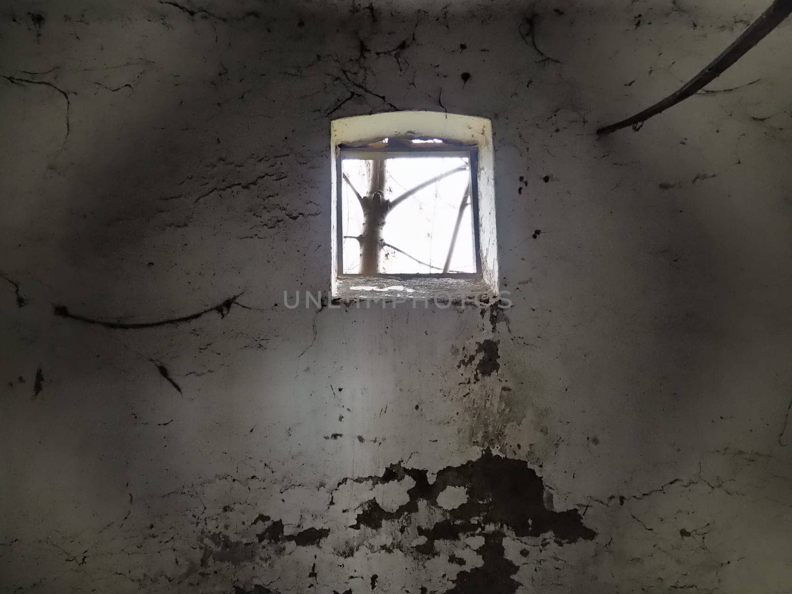 Scary walls with cobwebs. Old church dormer. A small window at the top of the wall. Halloween or haunted place. Prison cell with torture ropes. Visions and a world of hallucinations
