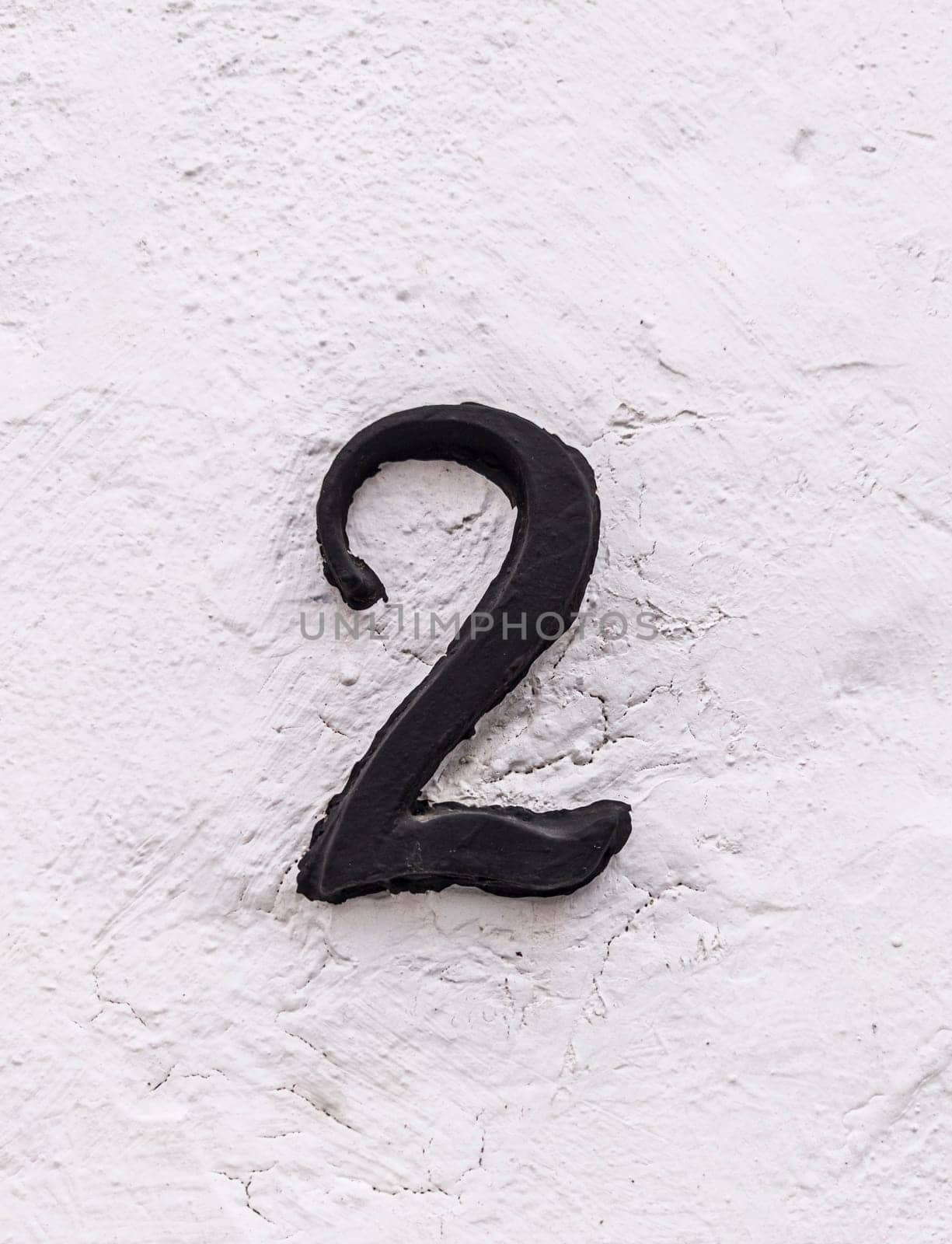 House number 2. Painted iron over whitewashed wall. Houses with personality concept