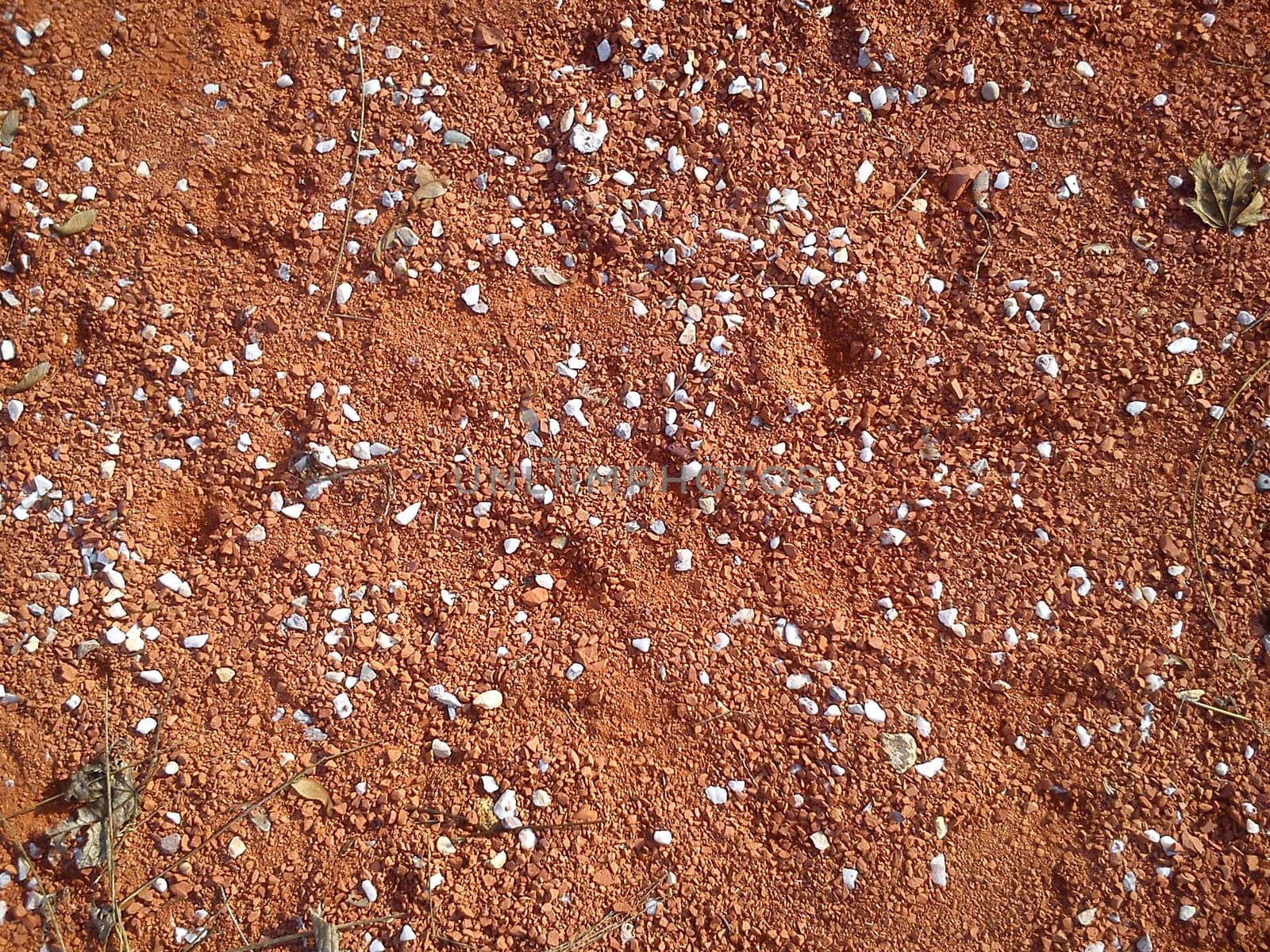 Fine decorative colored granite crushed stone. Red-brown colored stone chips used for landscape design. decoration and design. Crushed marble, granite, gravel or sand. Blotches of small white pebbles.
