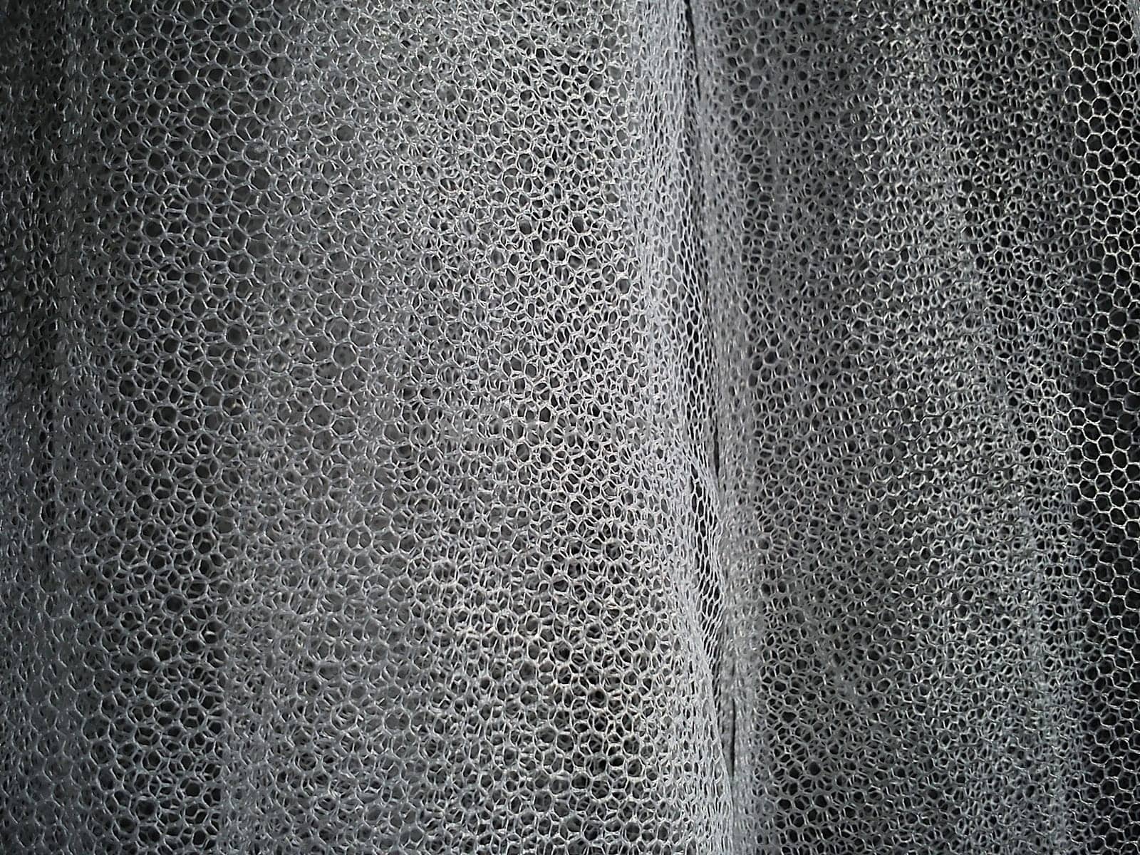 White wrinkled mesh fabric. A washable thing made of synthetic material. Mosquito net folded into soft folds. A bridal veil.