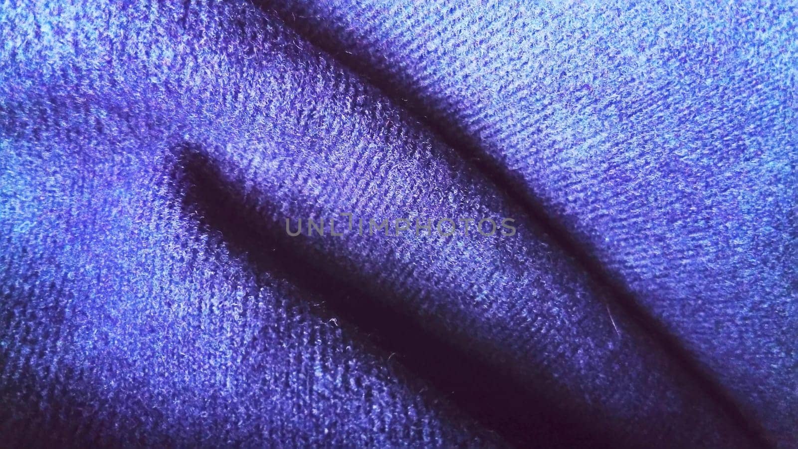 Dark blue fabric that looks like velvet or velveteen. Broken blue and violet waves