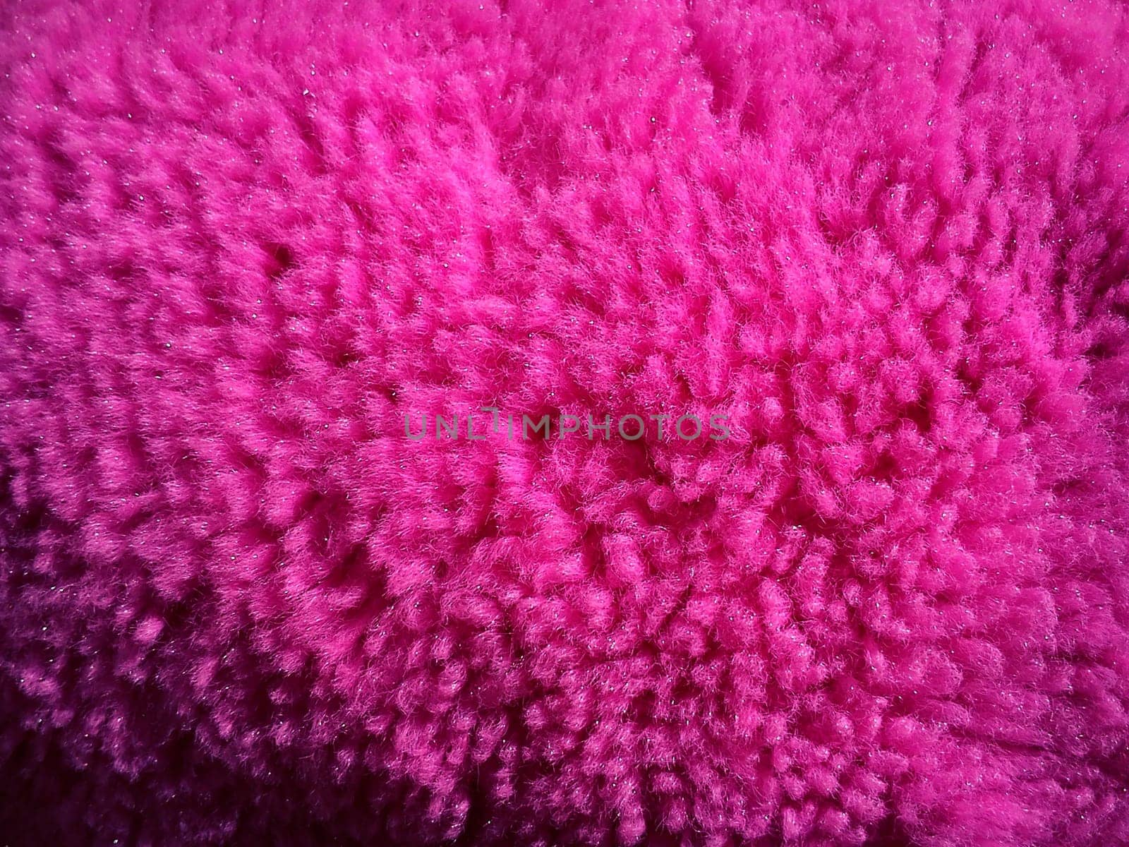 Faux fur or wool of bright pink and fuchsia color. Intense shade. Soft fluffy material for sewing toys, clothes or upholstery. Synthetic fibers. Light falls on the side. Long pile.