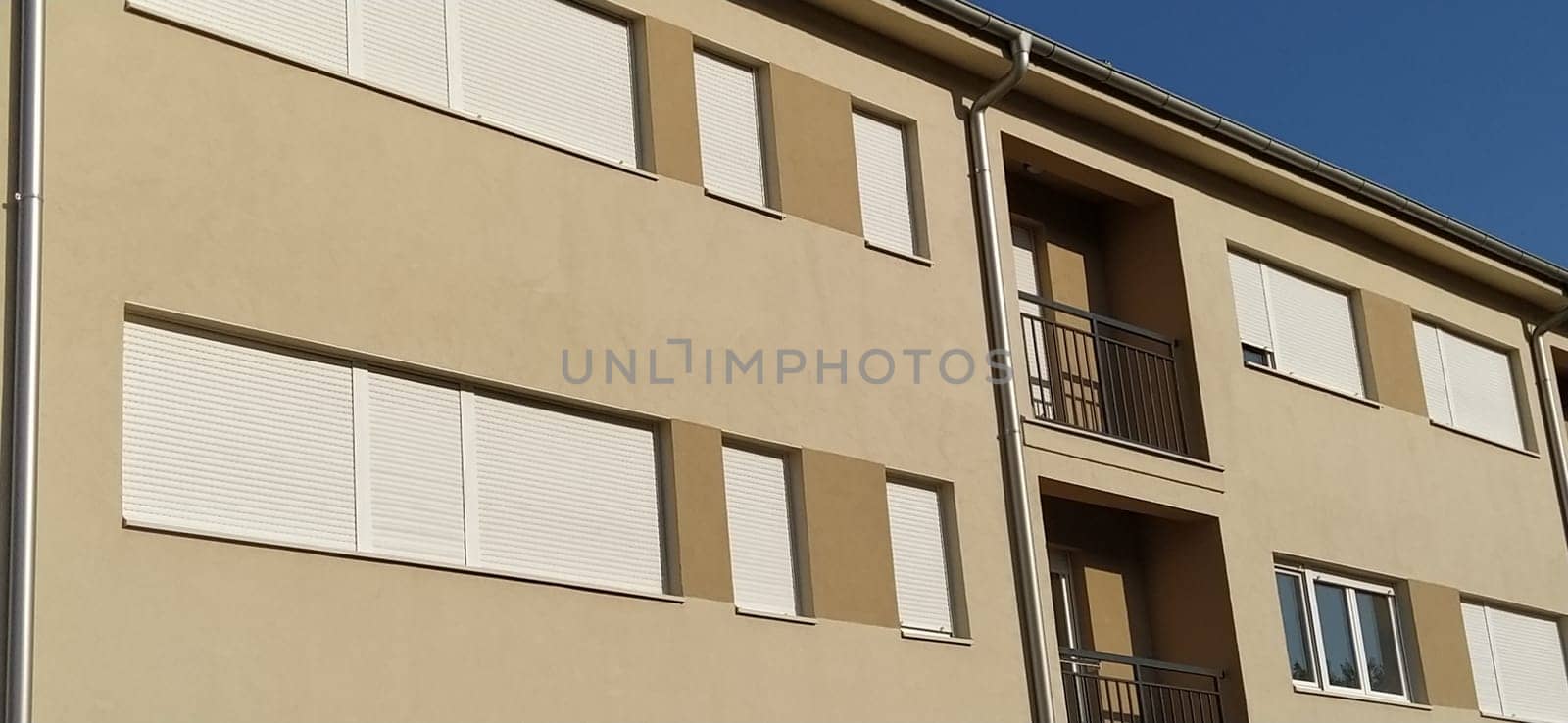 Facade of a new residential building. Modern buildings. Plaster beige wall.