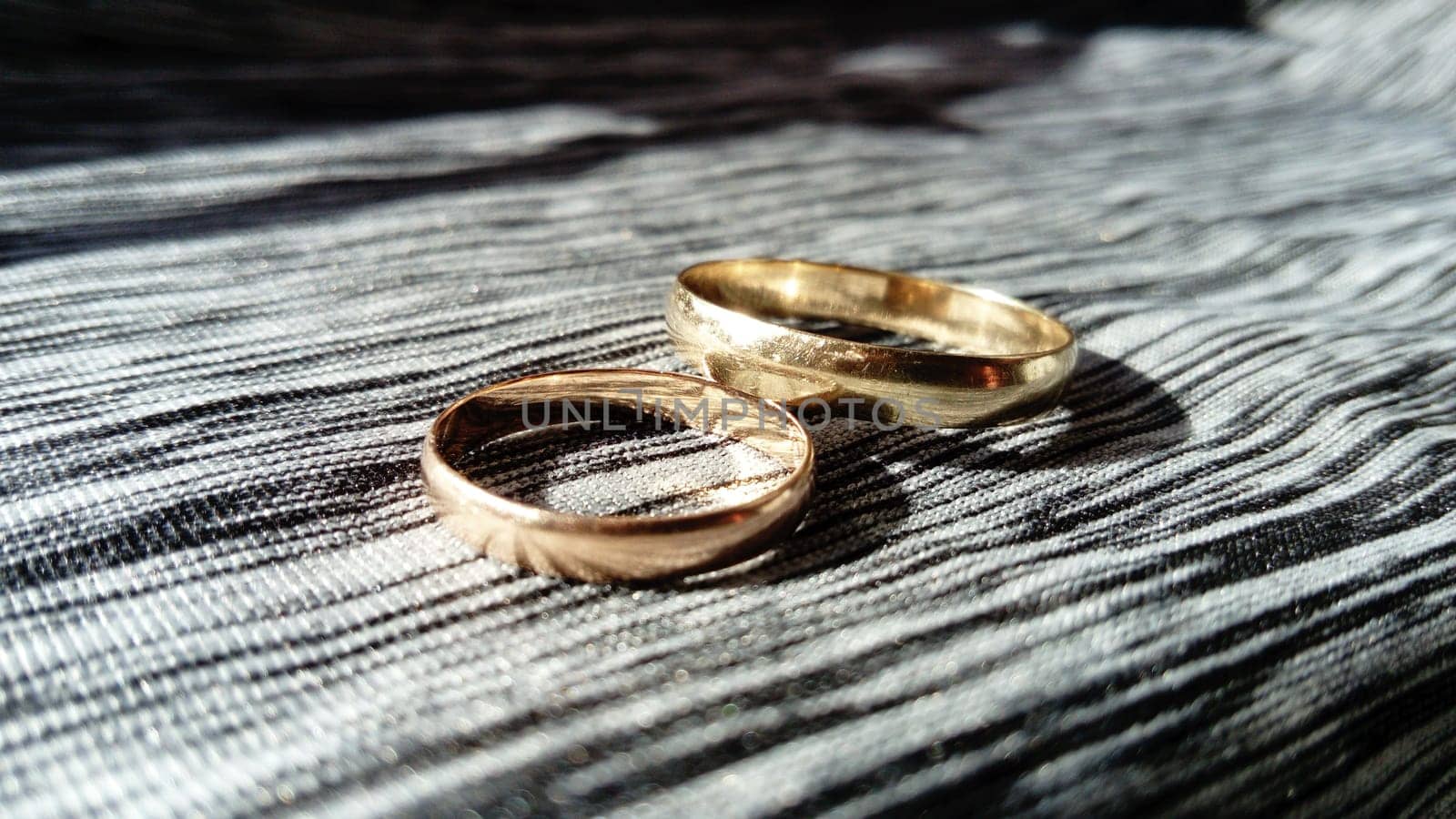 two gold rings, on a gray background