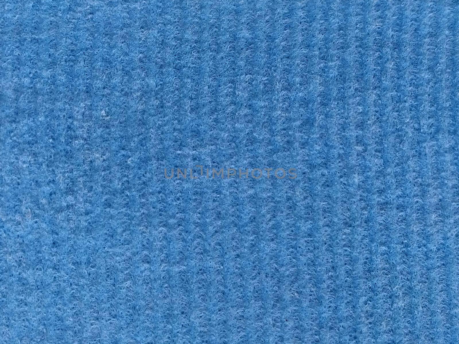 Close-up of a striped fabric with raised printing. Vertical stripes on blue microfiber or sponge.