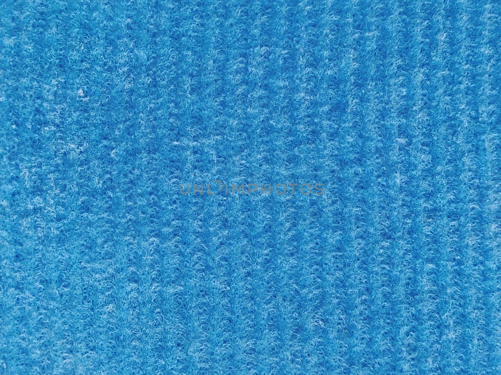 Close-up of a striped fabric with raised printing. Vertical stripes on blue microfiber or sponge.