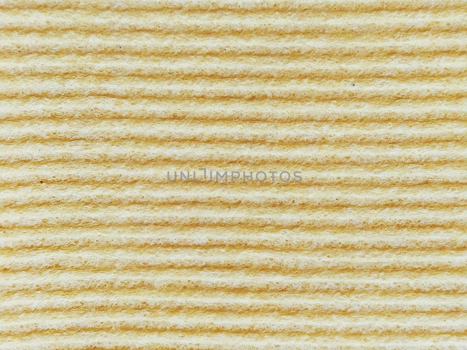 Close-up of a striped fabric with raised printing. Horizontal stripes on yellow microfiber or sponge