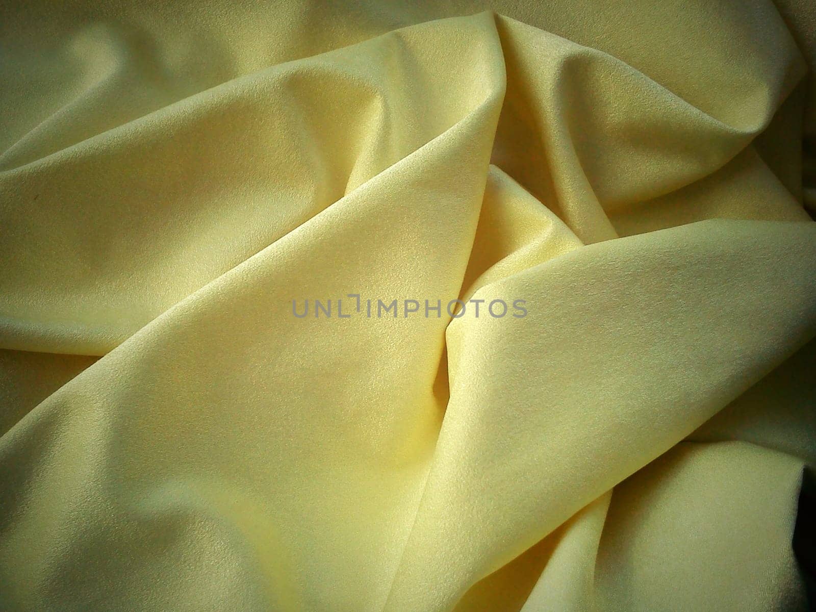 Beautiful velvet yellow curtains. Light negligence when folding the material. Soft, soft-touch curtains for the room or kitchen. Fabric for sewing clothes. Light dark edge vignetting.