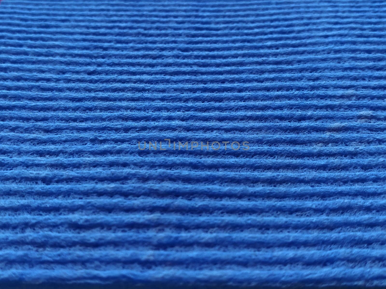 Blue striped ribbed fabric. Close-up shot of a dish washing sponge or microfiber cloth. Blur around the edges.