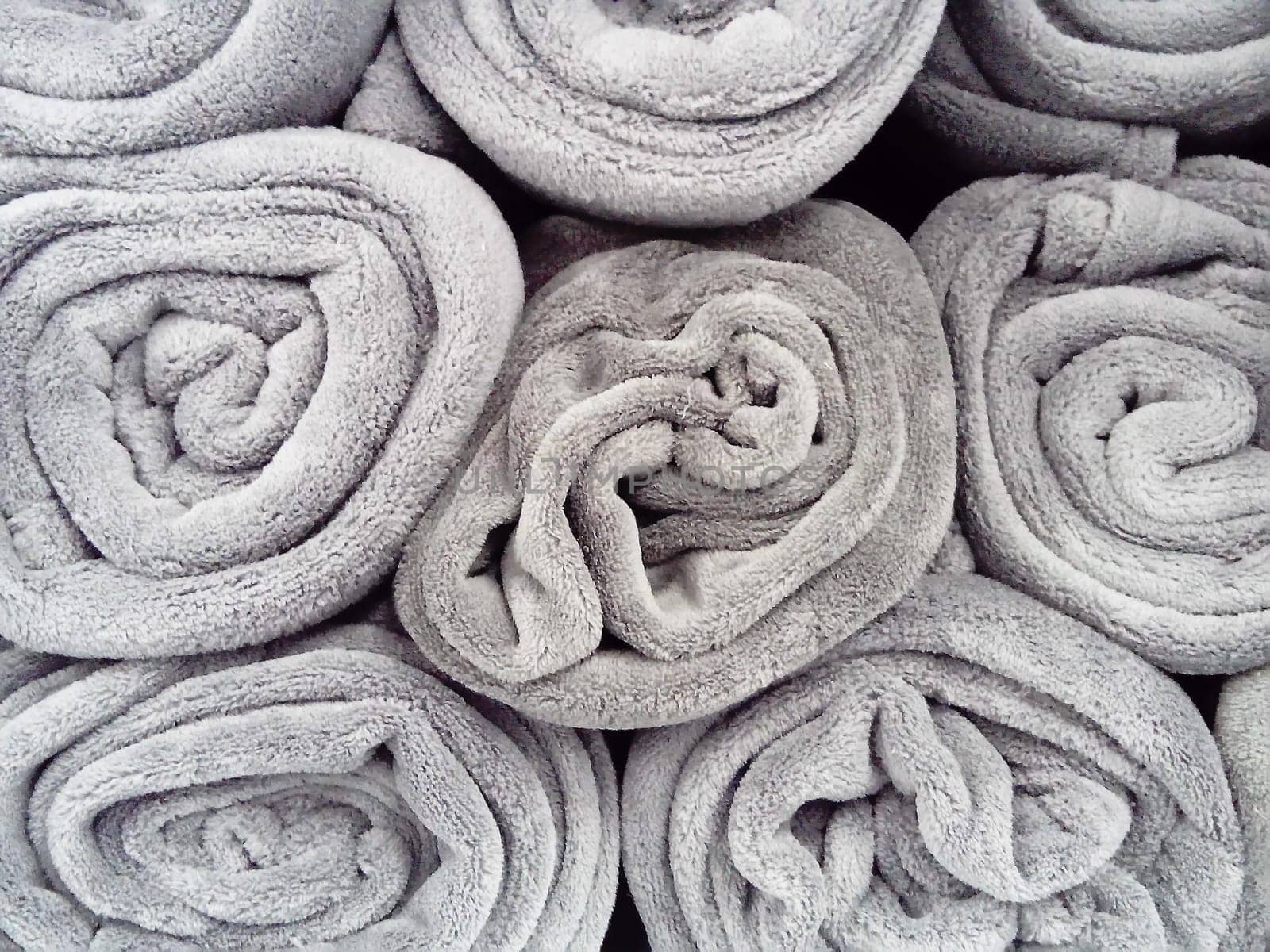 Gray blankets, rolled up and lying on a shelf in a store. Scandinavian lifestyle. Interior decor elements. Warm blankets.