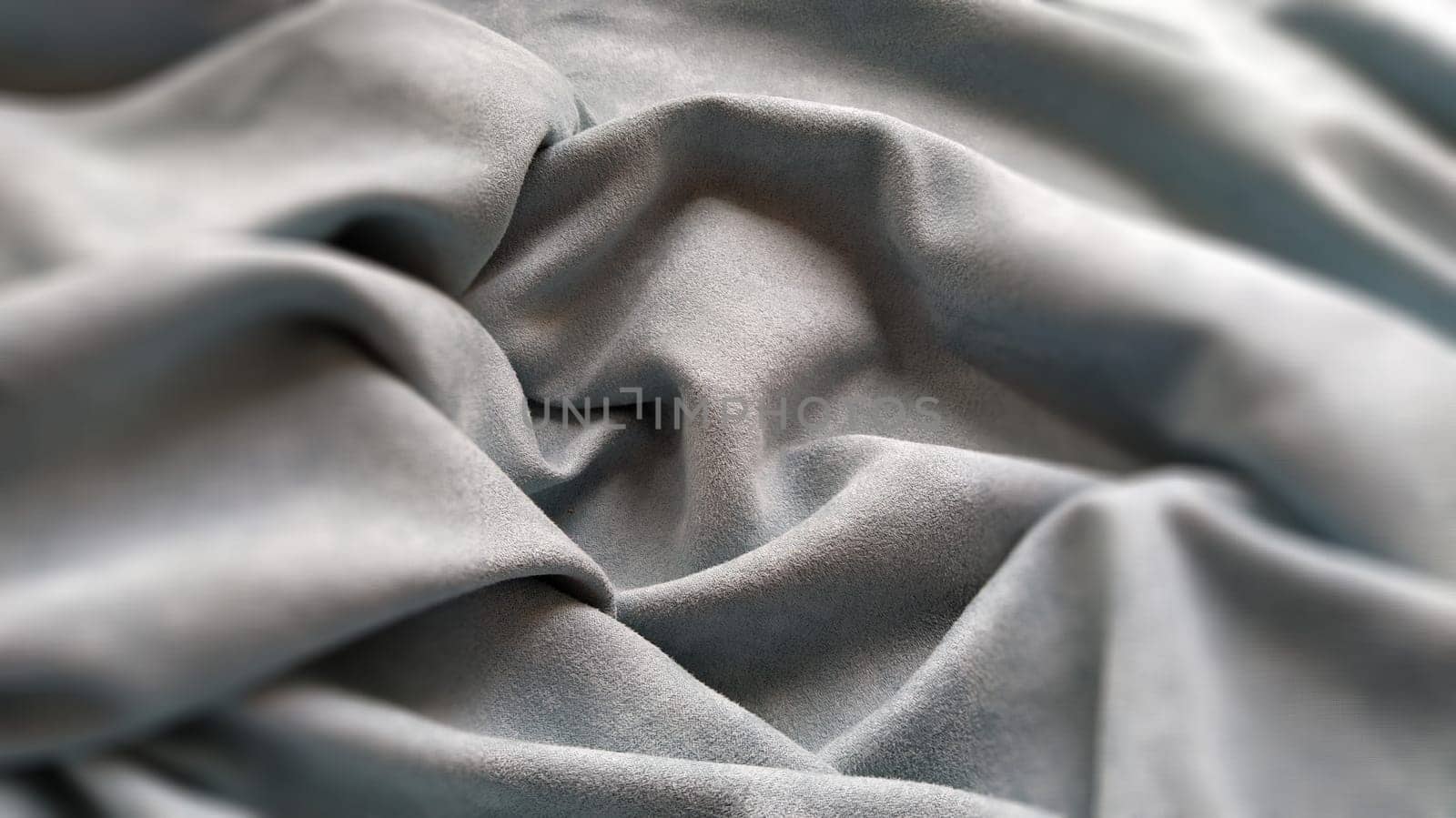 Fabric sheer curtain fabric. Beautiful gray-blue color. Soft velvet with a pile. The curtain material is carelessly folded and wrinkled on a horizontal surface. Fabric sample. Interior design option.