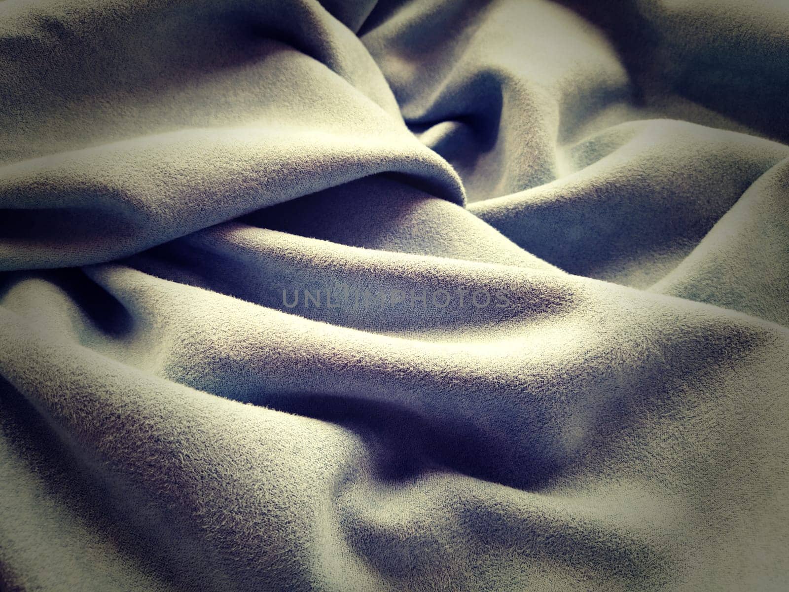 Cloth Curtain. Beautiful gray-blue color. Soft velvet with velvet. Curtain material folds casually on a horizontal surface. Sample fabric for the interior.Dark vignetting around the edges of the image