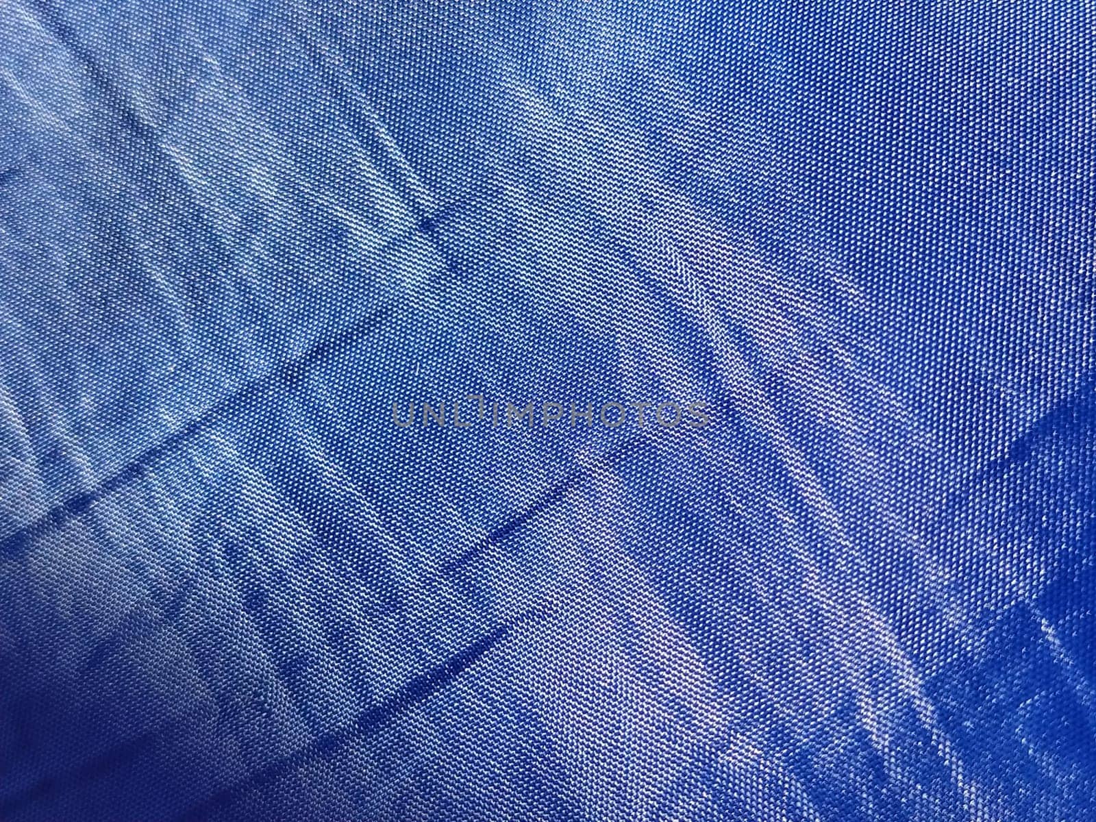 Blue silk lining. Close-up. A piece of fabric on curtains or a raincoat. Abstract macro image. Weaving thin threads.