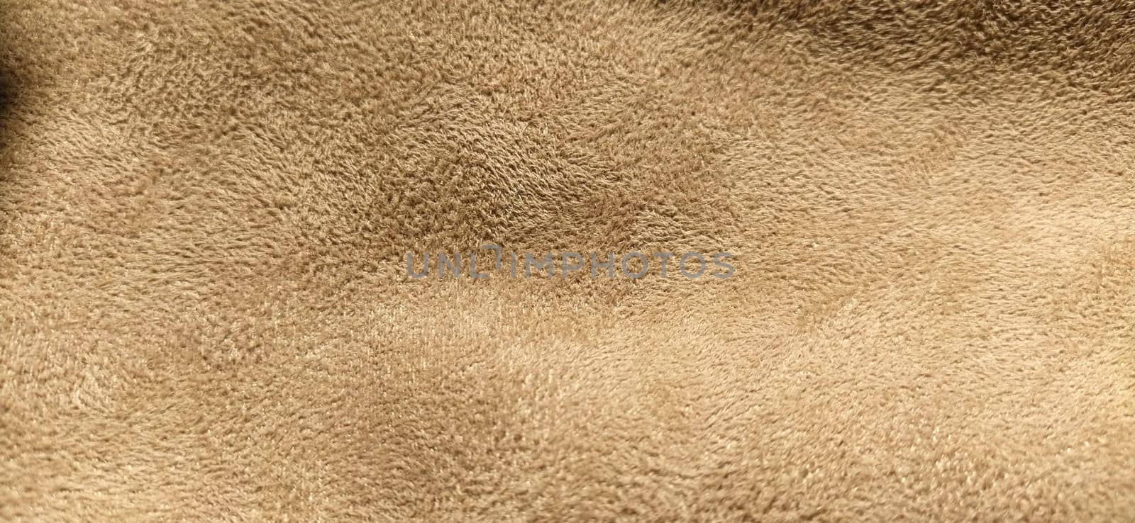 beige suede fabric. Close-up of a faux suede or nubuck fabric. Sewing accessories and fabrics. Short pile texture.