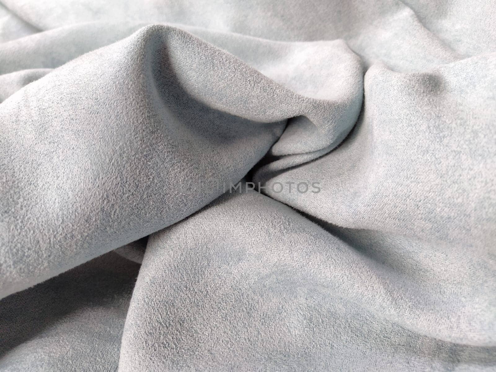 Fabric sheer curtain fabric. Beautiful gray-blue color. Soft velvet with a pile. The curtain material is carelessly folded and wrinkled on a horizontal surface. Fabric sample. Interior design option.
