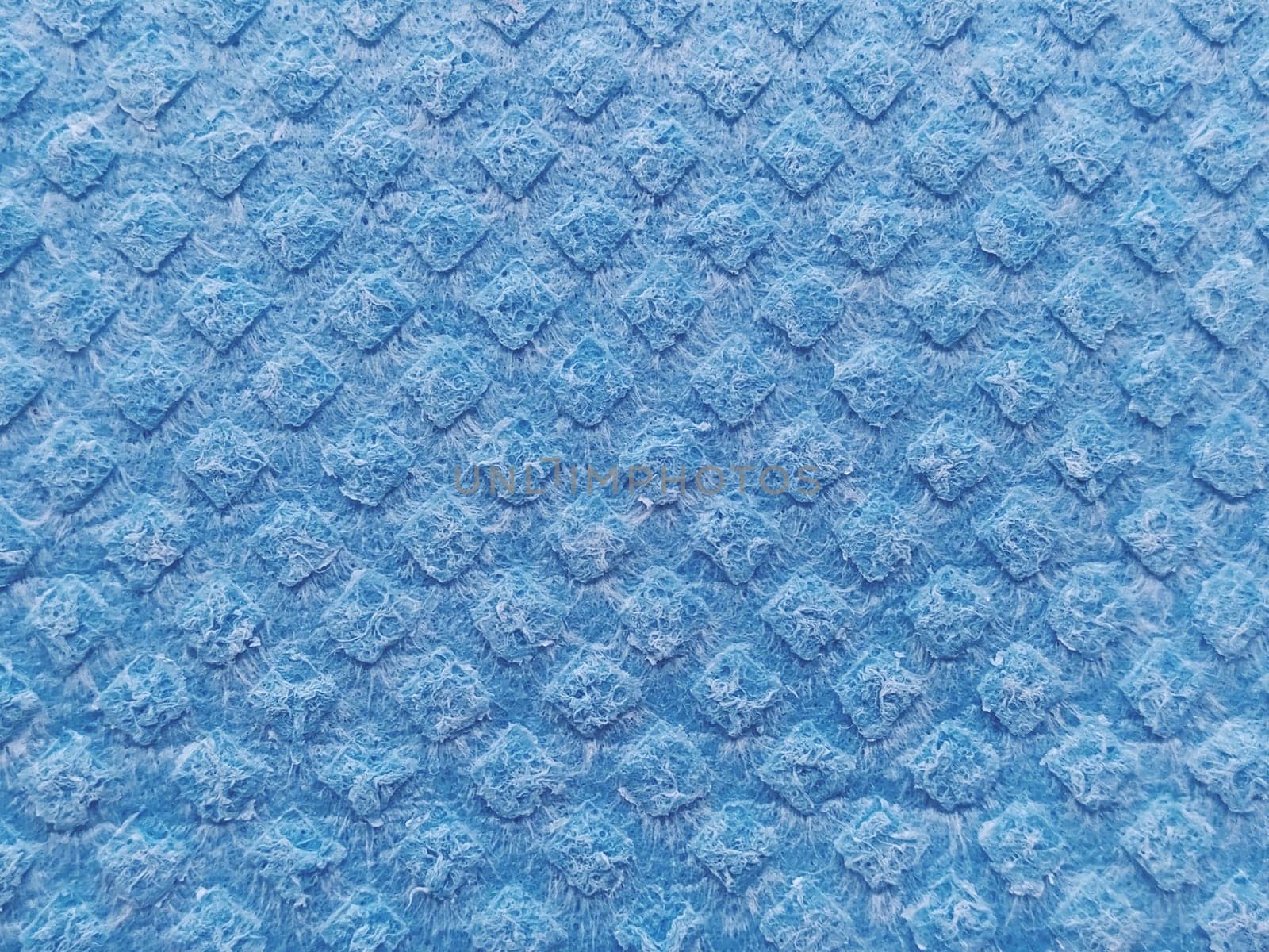 blue sponge for washing dishes, close-up. Abstract blue background.