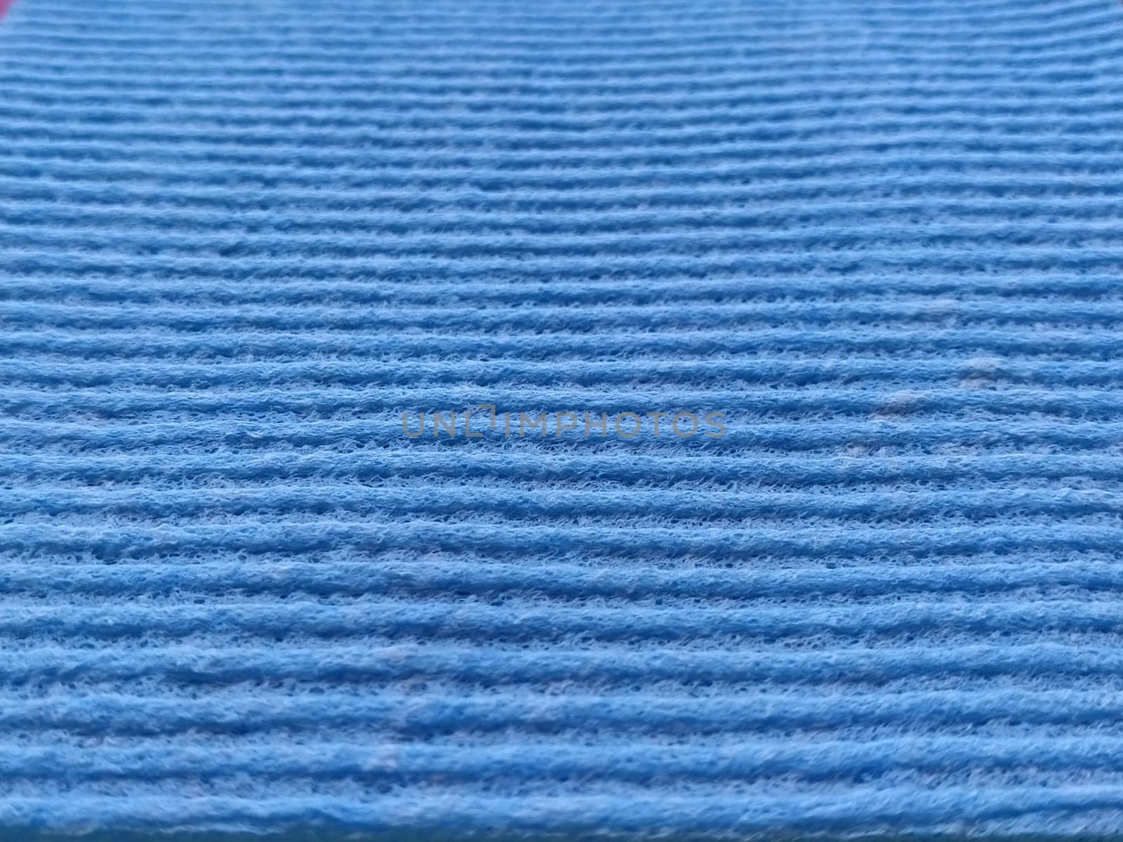 Blue striped ribbed fabric. Close-up shot of a dish washing sponge or microfiber cloth. Blur around the edges.