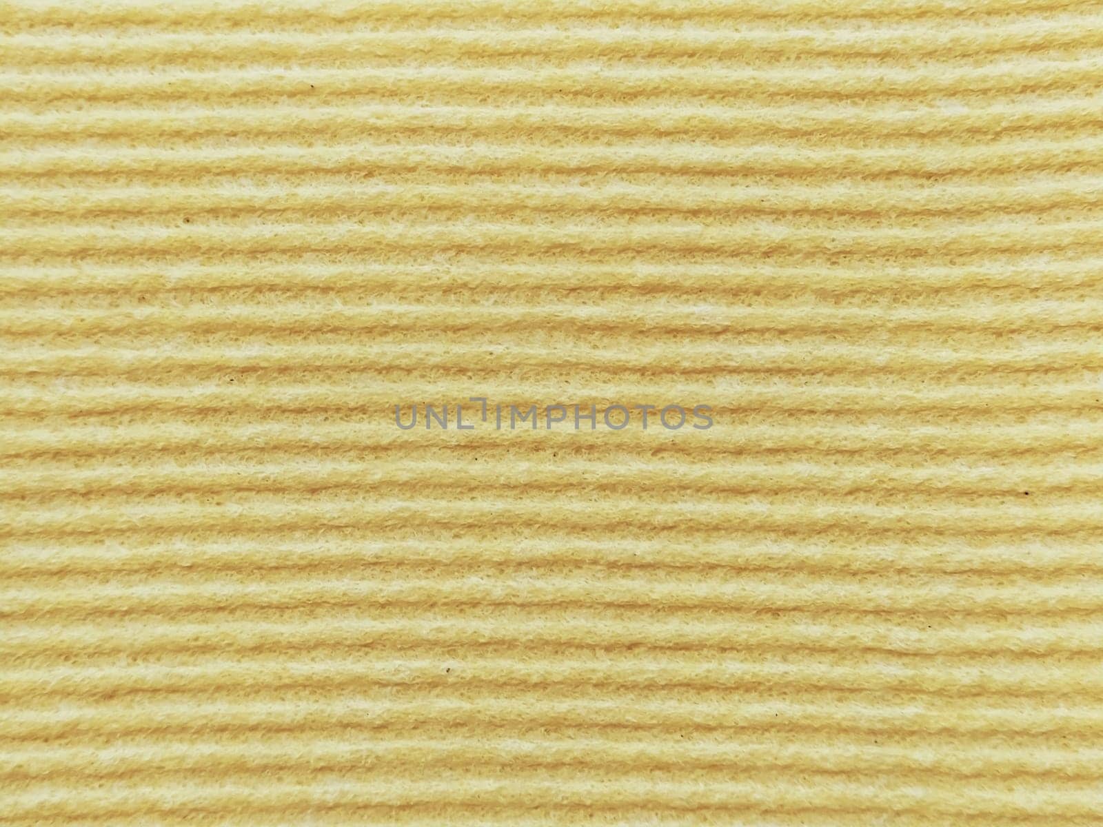 Close-up of a striped fabric with raised printing. Horizontal stripes on yellow microfiber or sponge.