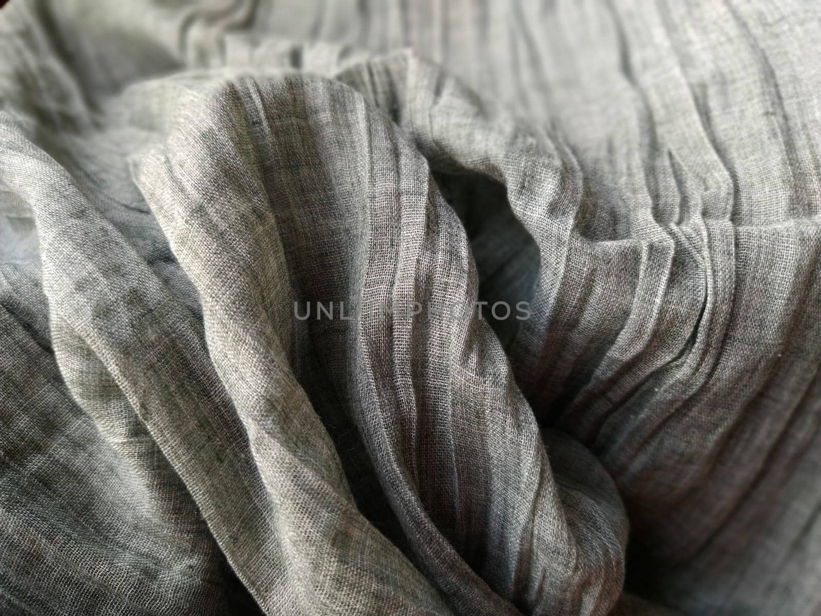Fabric sheer curtain fabric. Beautiful gray color. The curtain material is carelessly folded and wrinkled. Fabric sample. Interior design option.