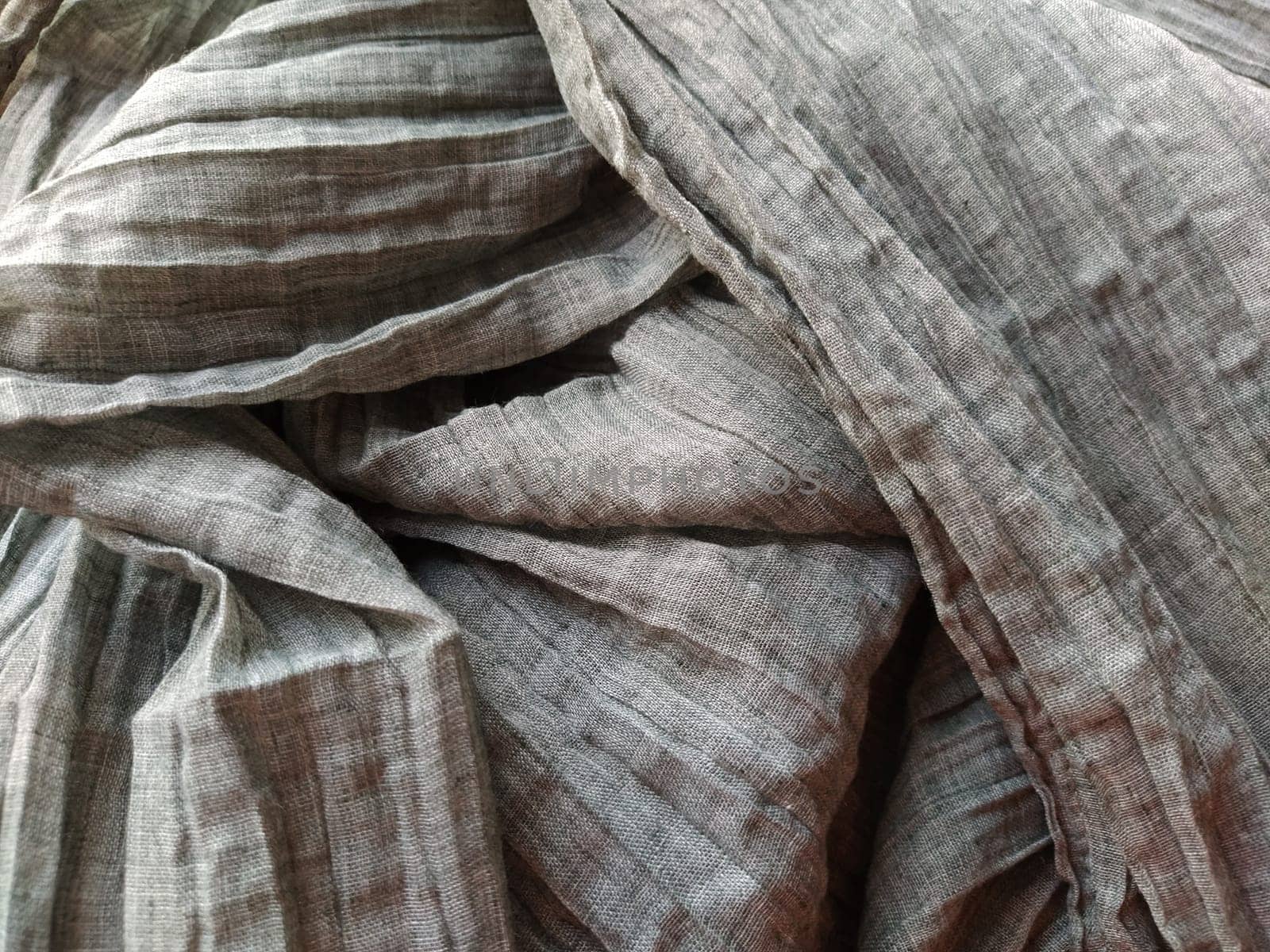 Fabric sheer curtain fabric. Beautiful gray color. The curtain material is carelessly folded and wrinkled. Fabric sample. Interior design option.
