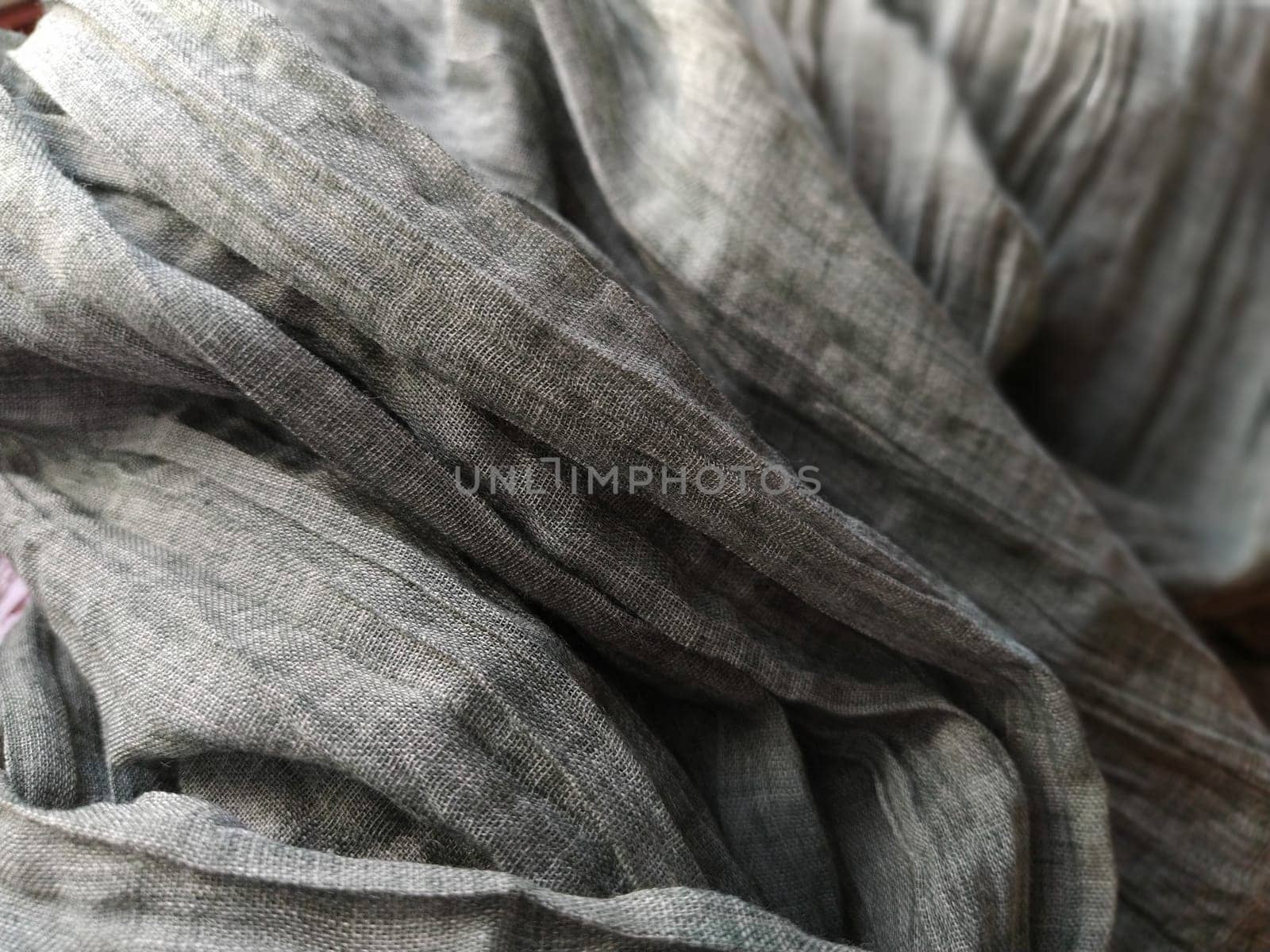 Fabric sheer curtain fabric. Beautiful gray color. The curtain material is carelessly folded and wrinkled. Fabric sample. Interior design option.