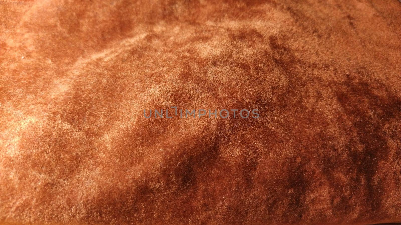 Red velvet. Close-up. Velvet fabric texture. Irregularities and overflows of light. Deep, rich, chocolate couloured satin. Folded and flowing background