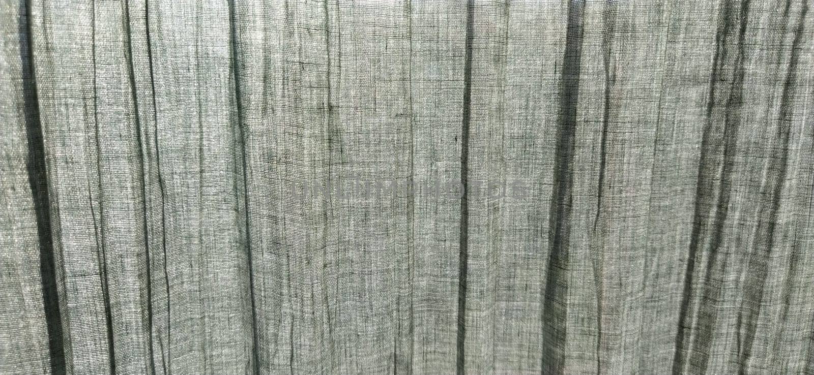 Gray pleated fabric or crumpled textile closeup. Light translucent curtains or tulle in the Scandinavian style. Soft focus. Pastel colors on the fabric