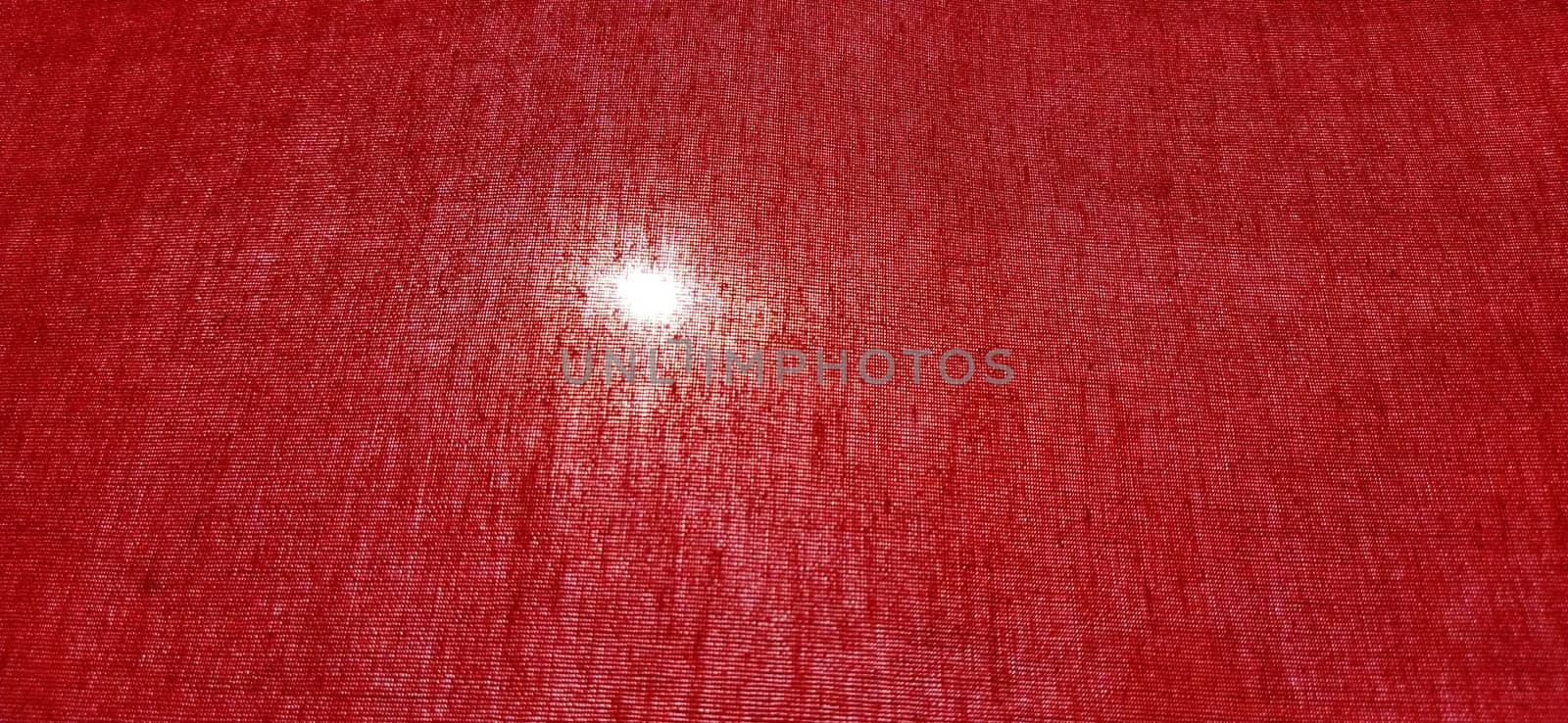 Sun or lamp through red blackout curtains. Bright red background with a glowing circle. Counter light
