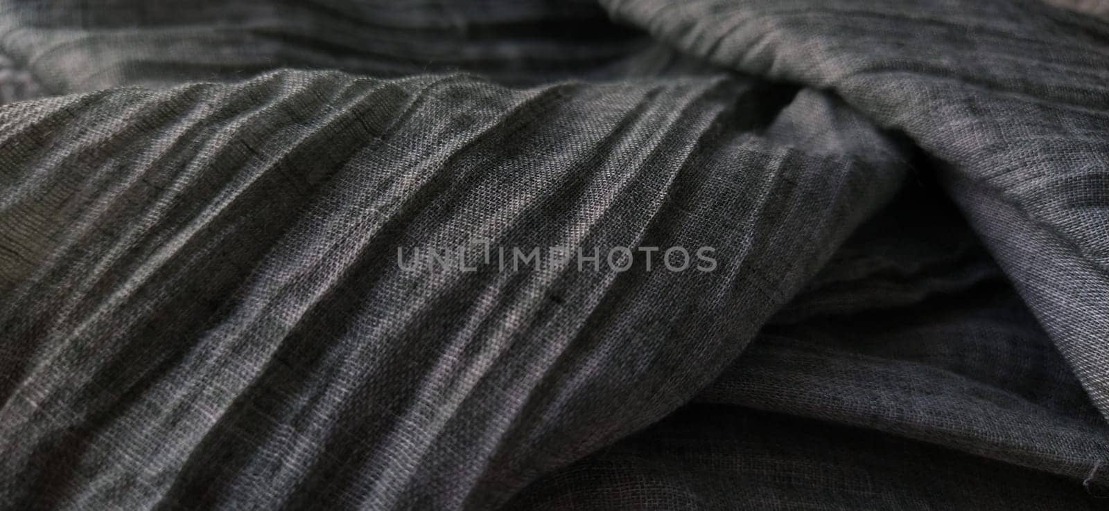 Gray pleated fabric or crumpled textile closeup. Light translucent curtains or tulle in the Scandinavian style. Soft focus.