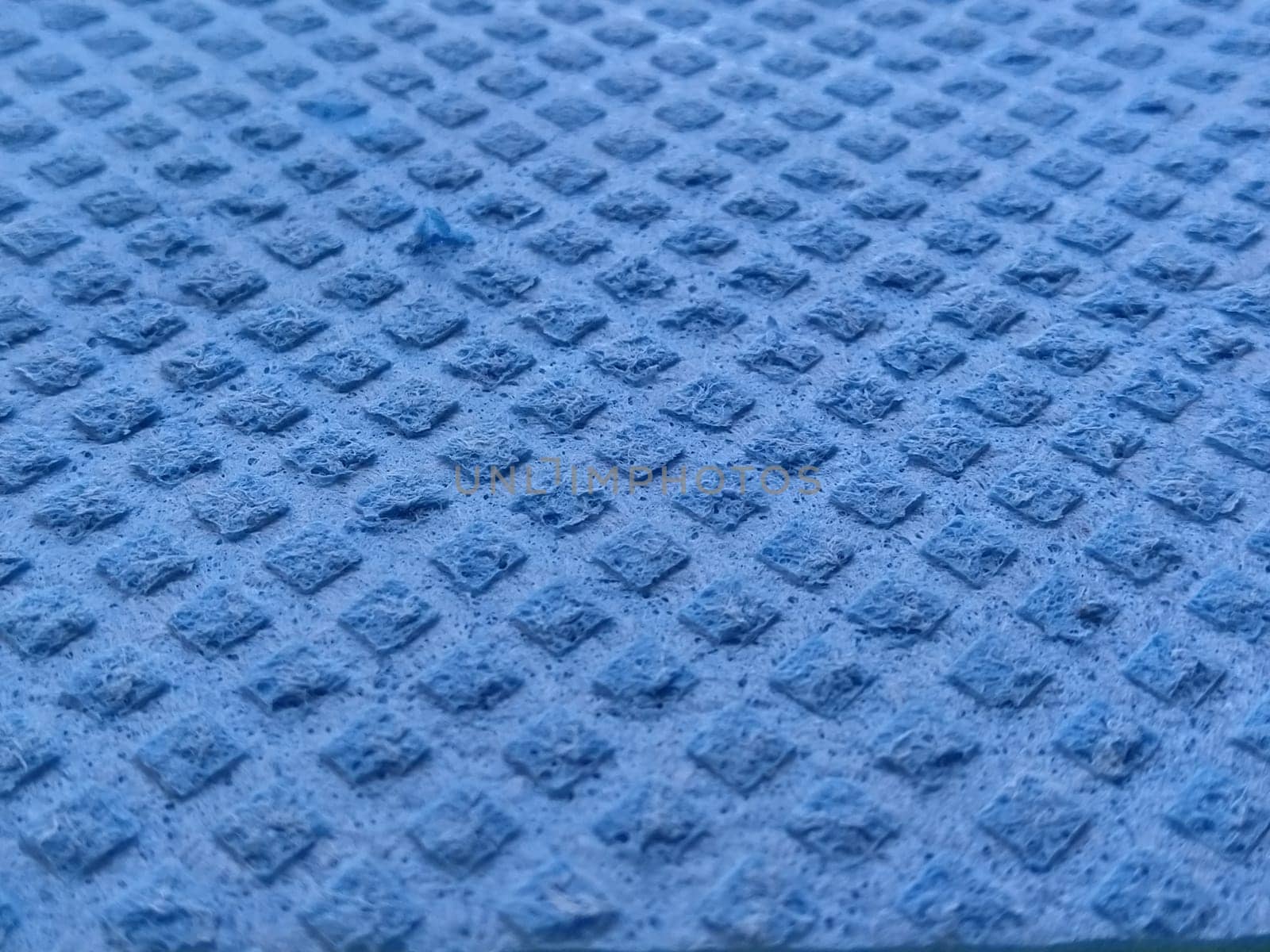 blue sponge for washing dishes, close-up. Abstract blue background. Soft focus.