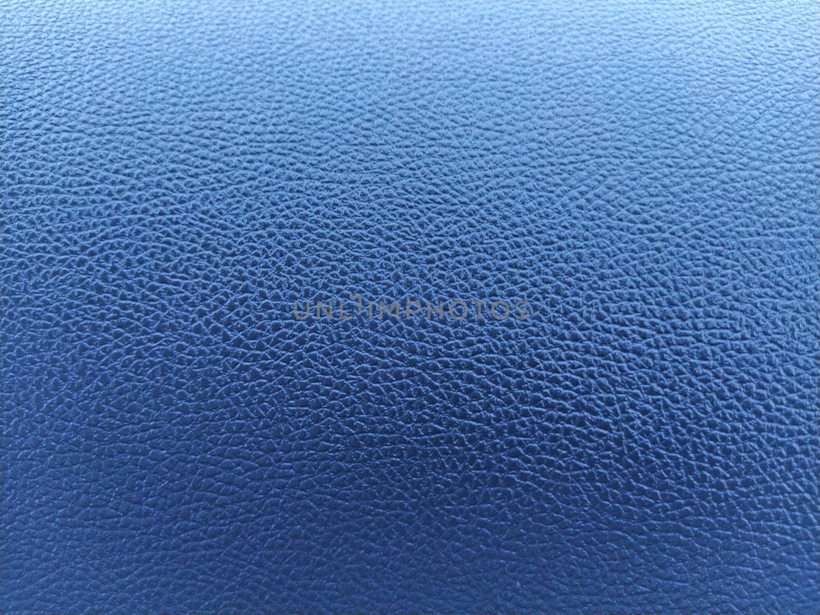 Blue leather background with rich texture. Close-up of artificial gray leather. A blurred background around the edges of the image.