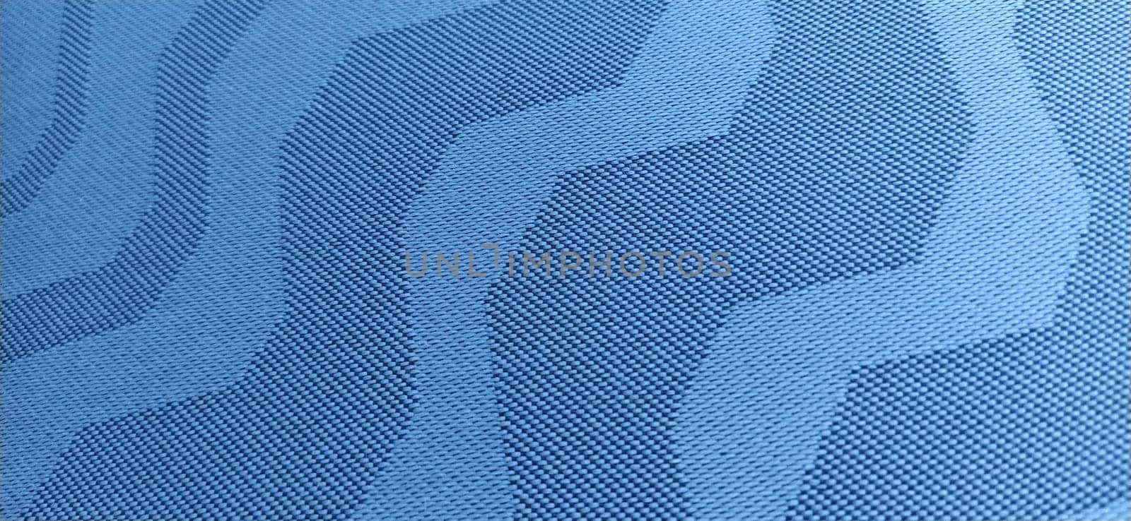 abstract blue curves on a gray background. Fabric texture. Wide lines and winding stripes.